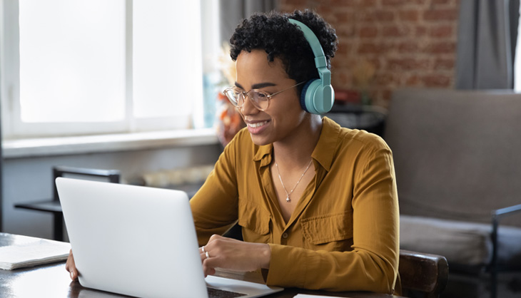 Woman in front of laptop with headphones